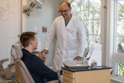 Dr. Hugo Campos discussing dental treatment with one of his patients