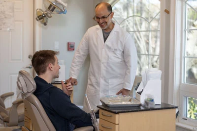 Dr. Hugo Campos discussing dental treatment with one of his patients